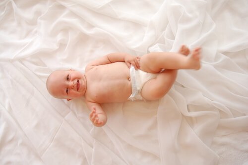 기저귀를 차고 누워서 웃고 있는 아기